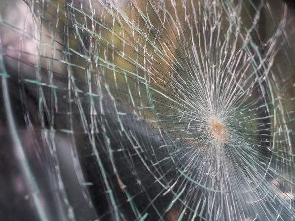 Glass broken cracks splinters in front of car ( Filtered image processed vintage effect. )